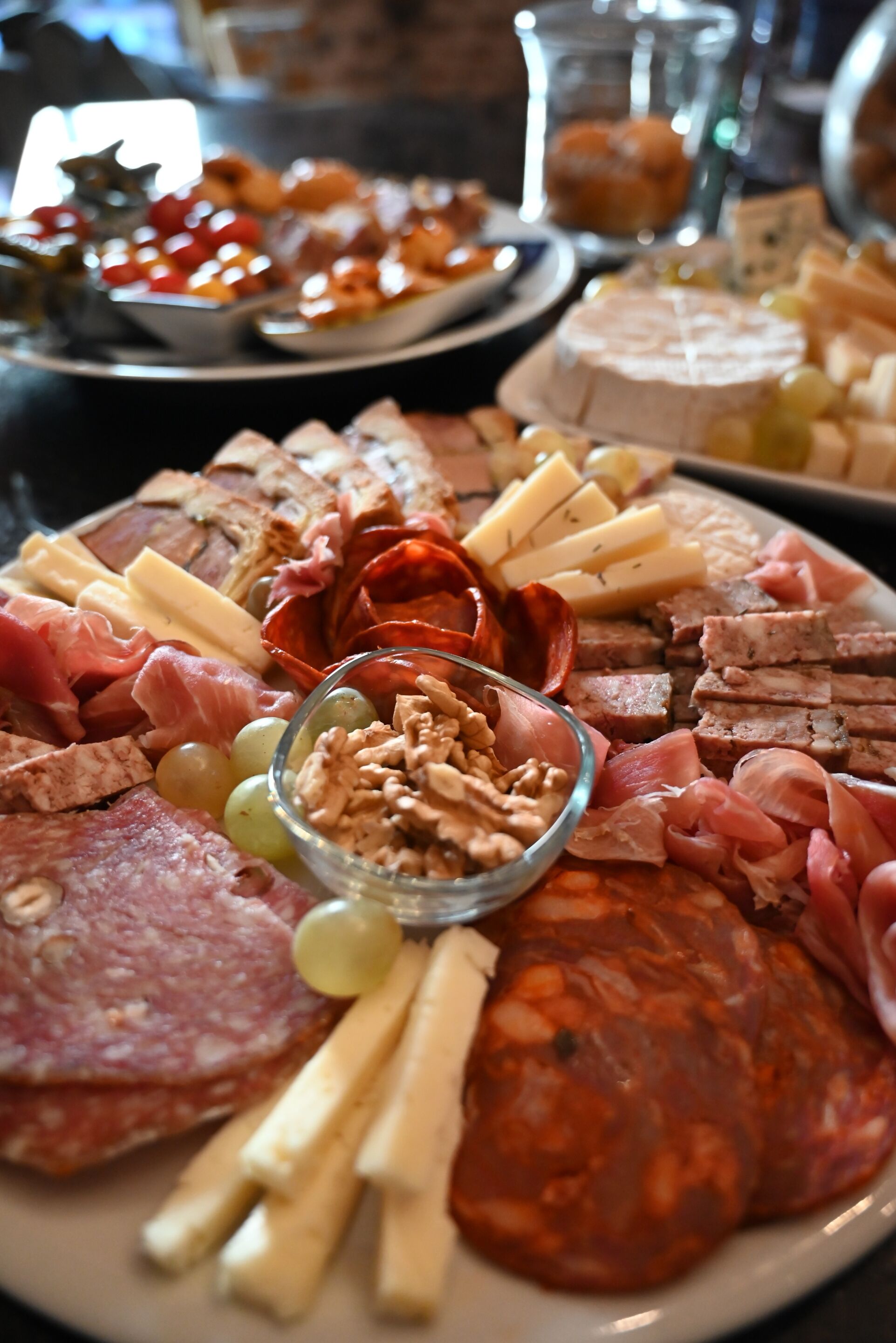 Una tabla de embutidos con carnes, quesos y frutas variadas.