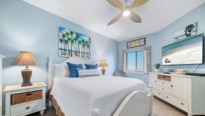 A bedroom with a bed, nightstands, a dresser, a ceiling fan, a beach-themed painting, and a TV. - RELAX AT THE  BEACH IN THIS GORGEOUS GULF FRONT CONDO! THE PALMS #914 (Orange Beach)