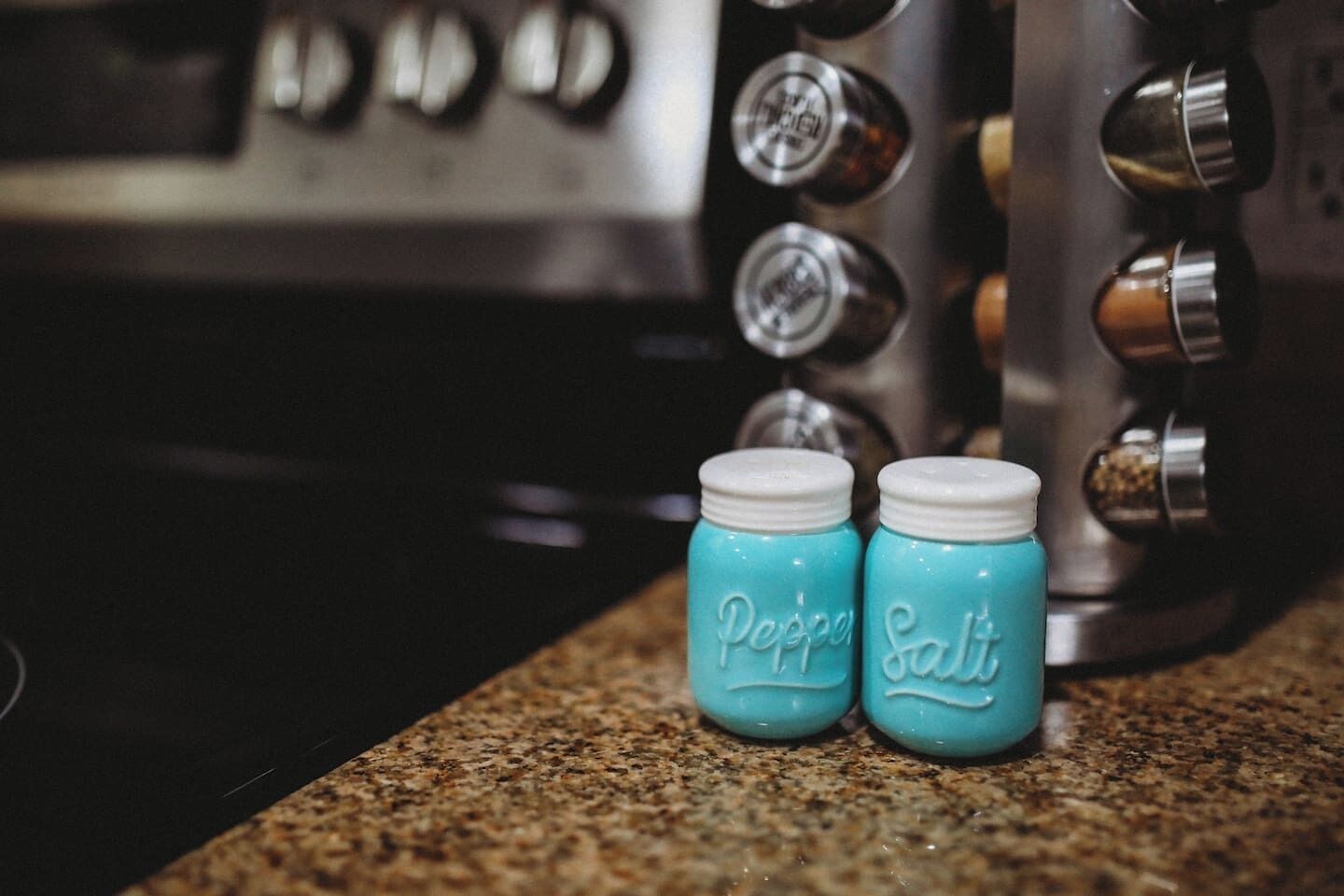 Two small jars labeled "Pepper" and "Salt" on a kitchen counter.