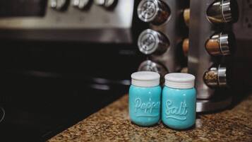 Two small jars labeled "Pepper" and "Salt" on a kitchen counter.