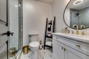 Een bad/douchecombinatie, een haardroger, handdoeken, zeep