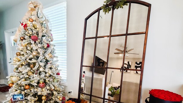 Un sapin de Noël décoré avec des cadeaux et un miroir ornemental.