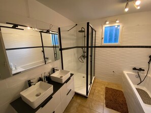Een bad/douchecombinatie, een haardroger, toiletpapier