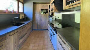 Een compacte keuken met houten kastjes, een inbouwoven en een spoelbak.