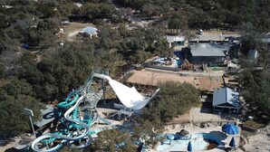 An aerial view of a theme park with a water ride, buildings, and surrounding vegetation. - The Best Little Shorehouse in Texas (Volente)