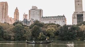 A gondola on a lake with buildings in the background.
