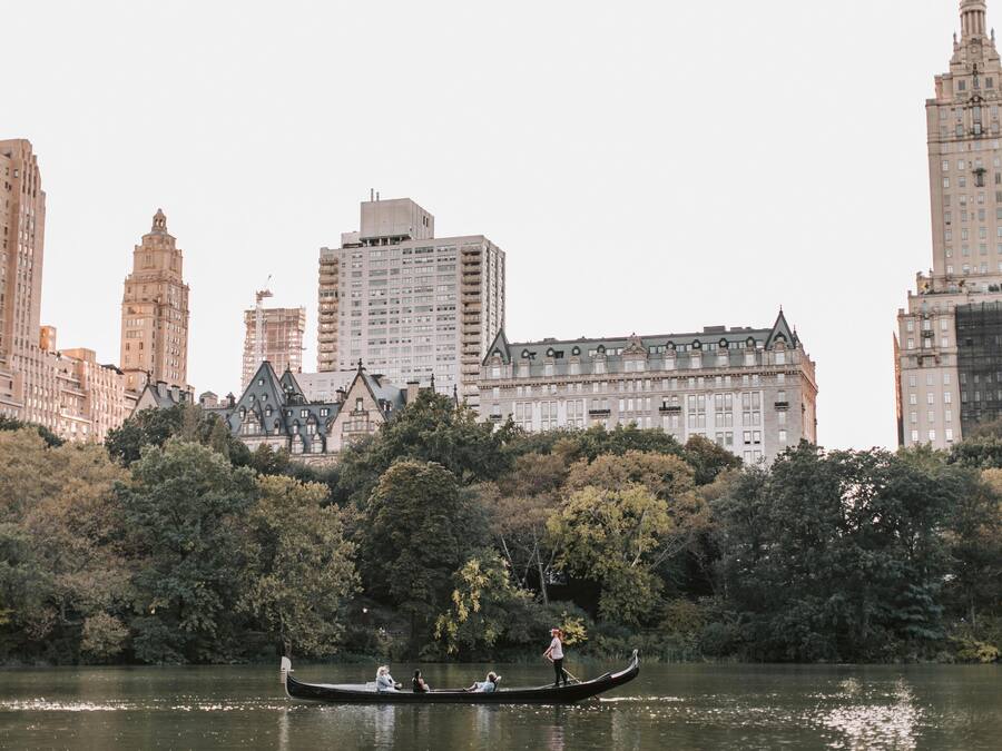 A gondola on a lake with buildings in the background.