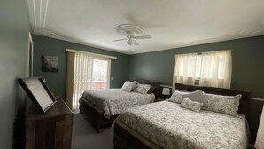 A bedroom with two beds, a ceiling fan, and a window with curtains. - Turkey Creek Retreats  (Belfry)