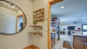 Una cocina moderna con electrodomésticos integrados, estantes de madera y un cartel de bienvenida.
