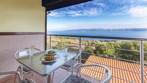 A balcony with a table set for two, overlooking a scenic view of the sea and hills. - Nice apartment in Labin with house sea view (Labin)