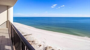 Un balcon avec vue sur une plage et l’océan.
