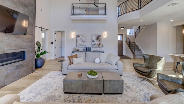 A spacious living area with a high ceiling, a fireplace, a sofa, a coffee table, and a staircase leading to an upper level. - New | Family Reunions | Corporate Retreats | Private Pool |  Sleeps 23 (Washington)