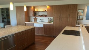 Una cocina moderna con armarios de madera, una isla central y un lavamanos integrado.