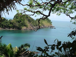 A coastal landscape with a view of the sea, a rocky shoreline, and dense greenery. - Villas Yulli (Tela)
