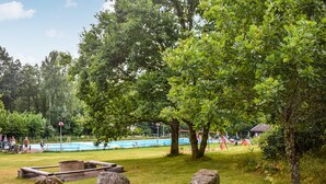 A park with a swimming pool, trees, and a playground. - 7 bedroom awesome home in örkelljunga (Örkelljunga)