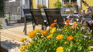 An outdoor seating area with a wooden deck, two black metal chairs, and a table. - 7 bedroom awesome home in örkelljunga (Örkelljunga)