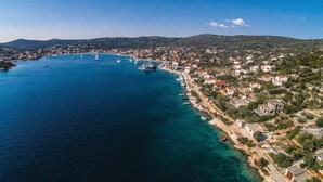 An aerial view of a coastal town with a marina, houses along the shore, and hills in the background. - Gorgeous home in Vinisce with house sea view (Vinisce)