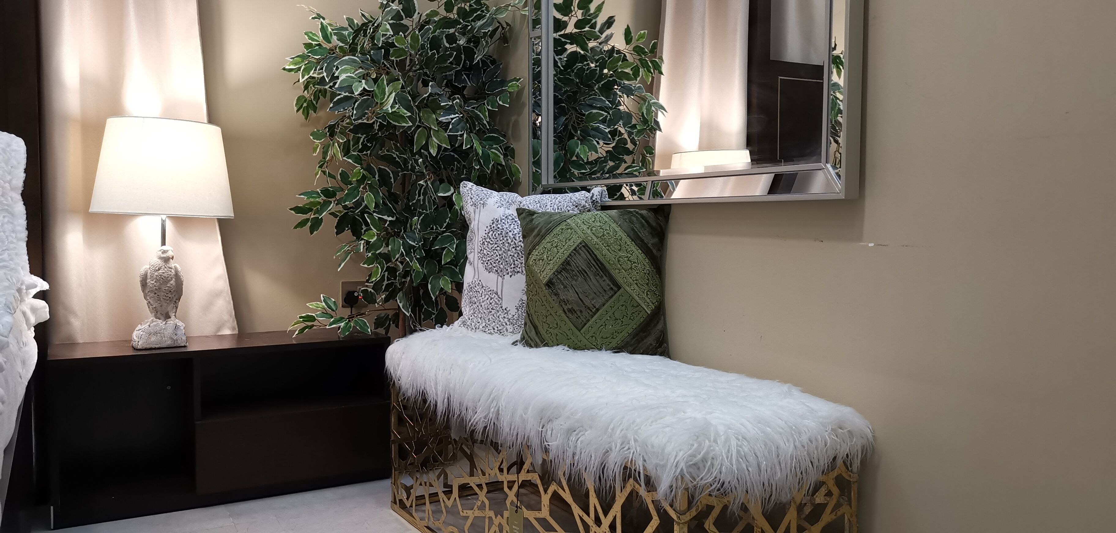Una habitación pequeña y acogedora con cama, mesita de noche, lámpara y espejo.