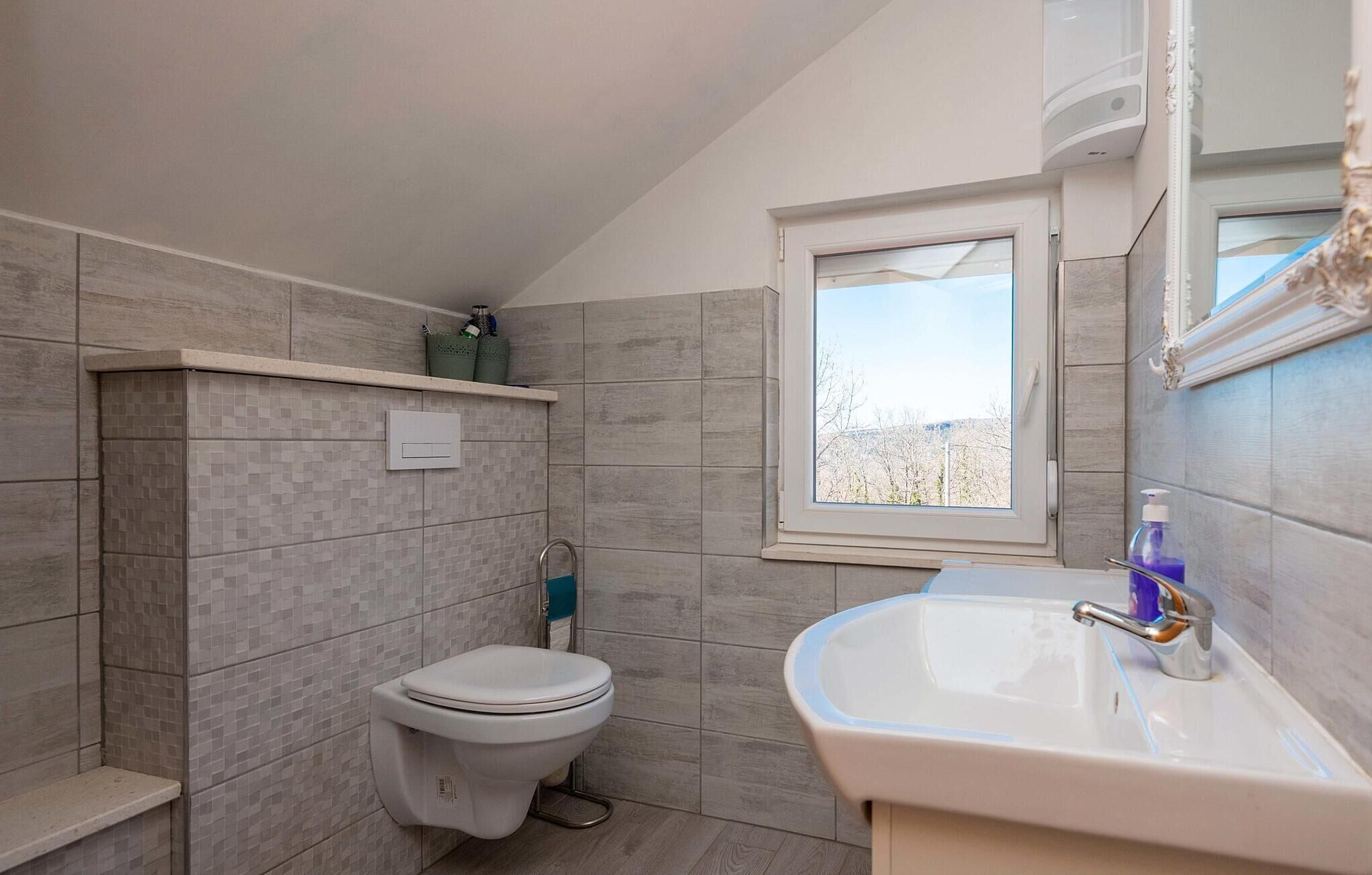 Un bagno con il water, un lavandino e una finestra.