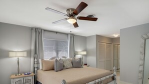 A bedroom with a bed, a ceiling fan, bedside lamps, a nightstand, and a wardrobe. - Canal Home to Gulf Completely Renovated, Large Pool, come to Serenity Retreat!!! (Englewood)