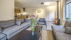 Ein modernes Wohnzimmer mit grauen Sofas, einem Couchtisch und einem Kamin.
