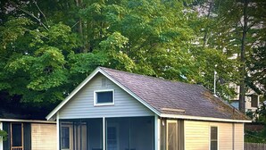 A single-story house with a front porch, a screened porch, and a small deck.