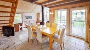 A cozy cabin interior with a dining area, sofa, and a large window overlooking a yard. - Nice home in Rechlin with sauna (Rechlin)