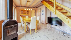 A wooden interior with a dining area, a TV on a stand, and a staircase. - Nice home in Rechlin with sauna (Rechlin)