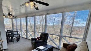 A spacious room with a large window, a ceiling fan, and a seating area with a couch and a chair. - Woodson Bend-Golf, Pool Restaurant& More-Near Burnside W/Lake View - First Floor (Bronston)