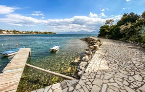 A clear waterfront with a wooden dock and a stone pathway leading to the water. - 1 bedroom stunning apartment in Nafpaktos (Nafpaktos)