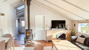 Una sala de estar acogedora con chimenea, televisión y comedor.