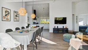 Un espace de vie moderne comprenant un coin repas, une cuisine et un espace détente.