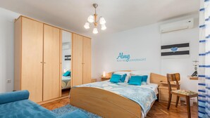Un dormitorio con cama, armario, escritorio y silla.