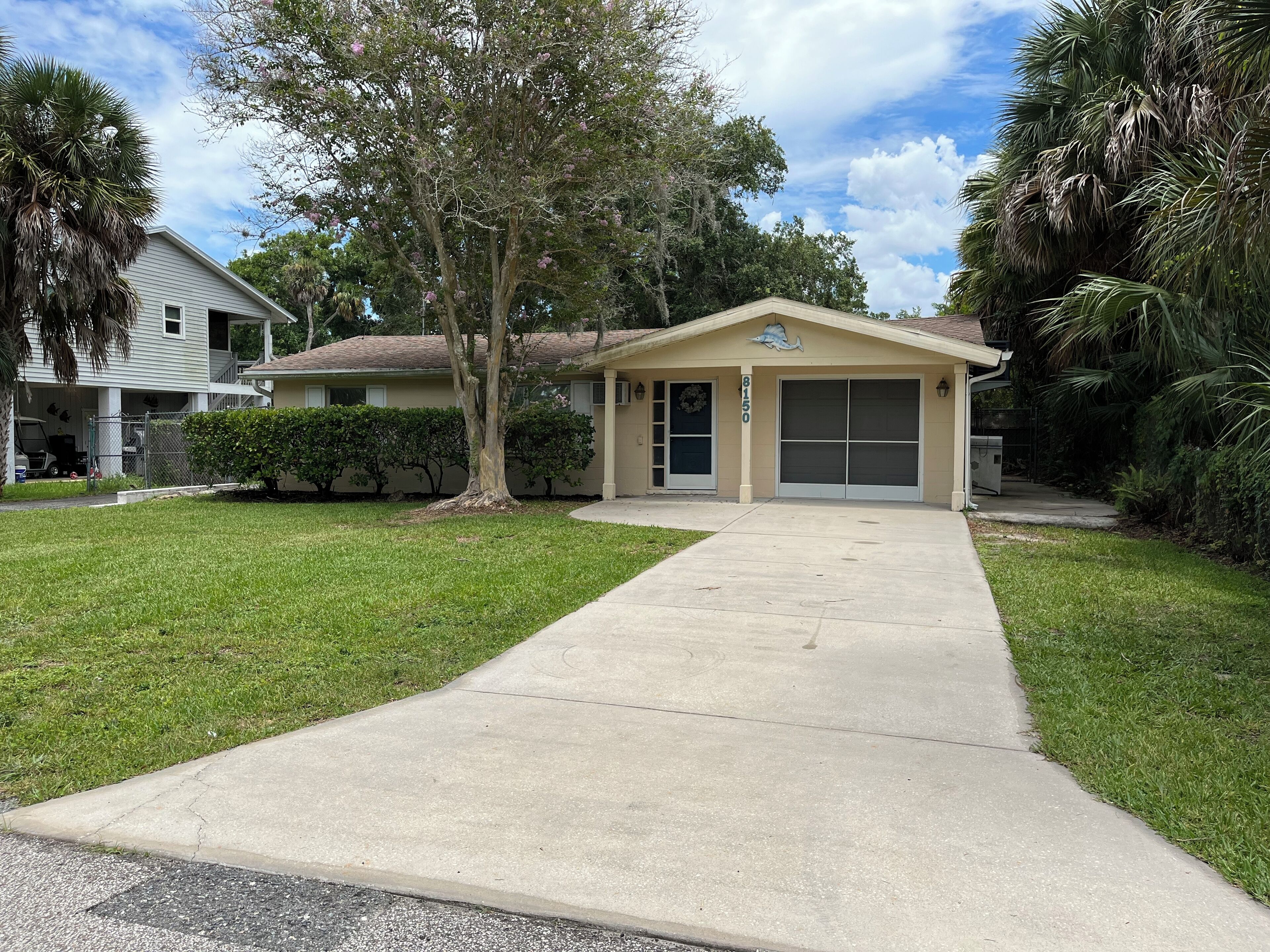 A single-story house with a garage, a covered porch, and a well-maintained lawn.