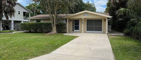 A single-story house with a garage, a covered porch, and a well-maintained lawn.