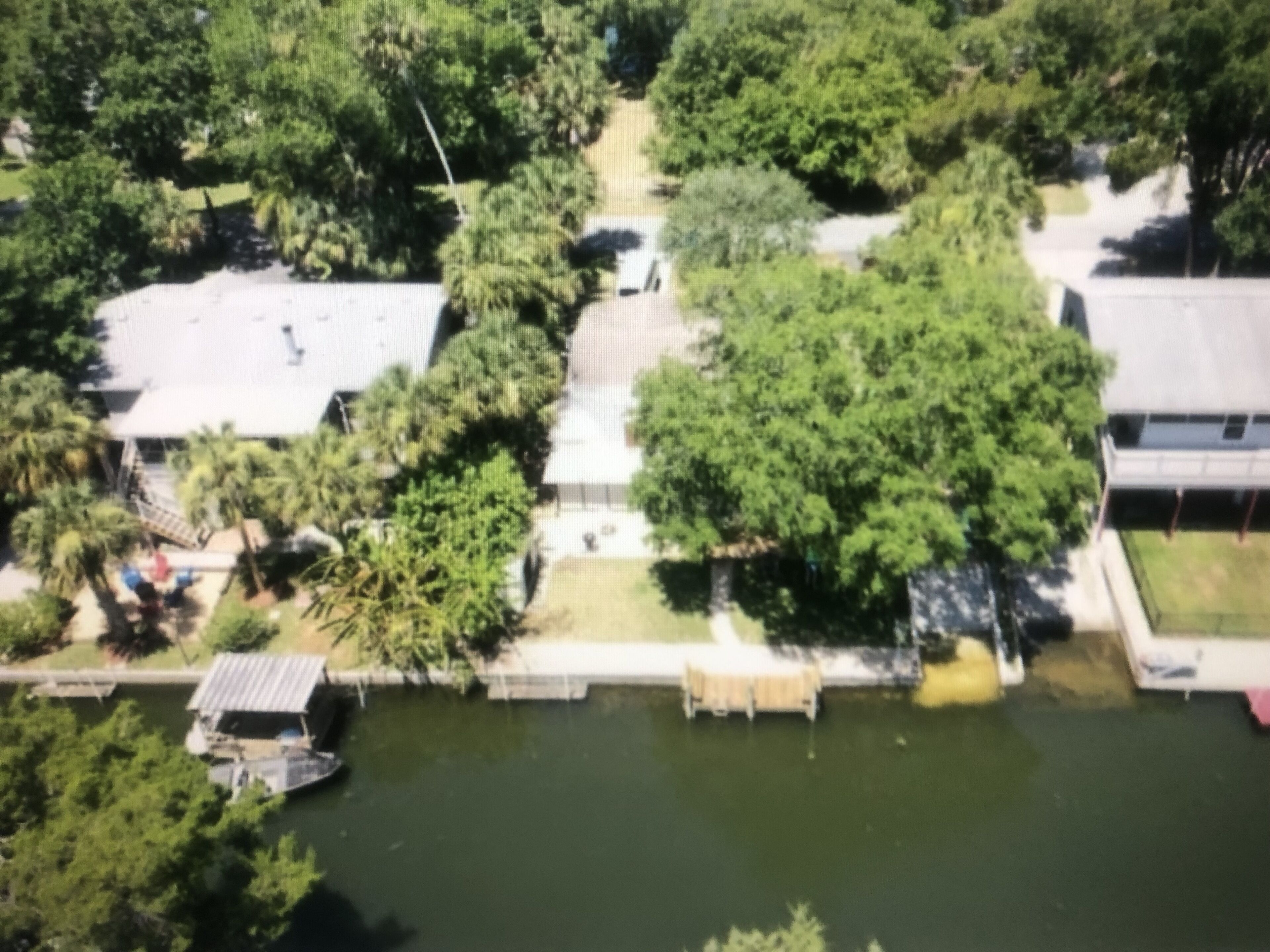 Vista aérea de una zona residencial con casas, un muelle y un río.
