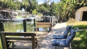A dock with a bench and a small boat docked nearby. - WATERFRONT DEAL! Boat Dock/Ramp•Kayaks•SUP•Easy Gulf•Fish•Manatees, Dog friendly (Weeki Wachee Gardens)