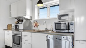 A modern kitchen with white cabinetry, stainless steel appliances, and a window above the sink. - Stunning home in Nexø with WiFi (Nexø)