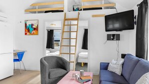 A modern, well-lit room with a bunk bed, a desk, a chair, a couch, and a flat-screen TV. - Stunning home in Nexø with WiFi (Nexø)