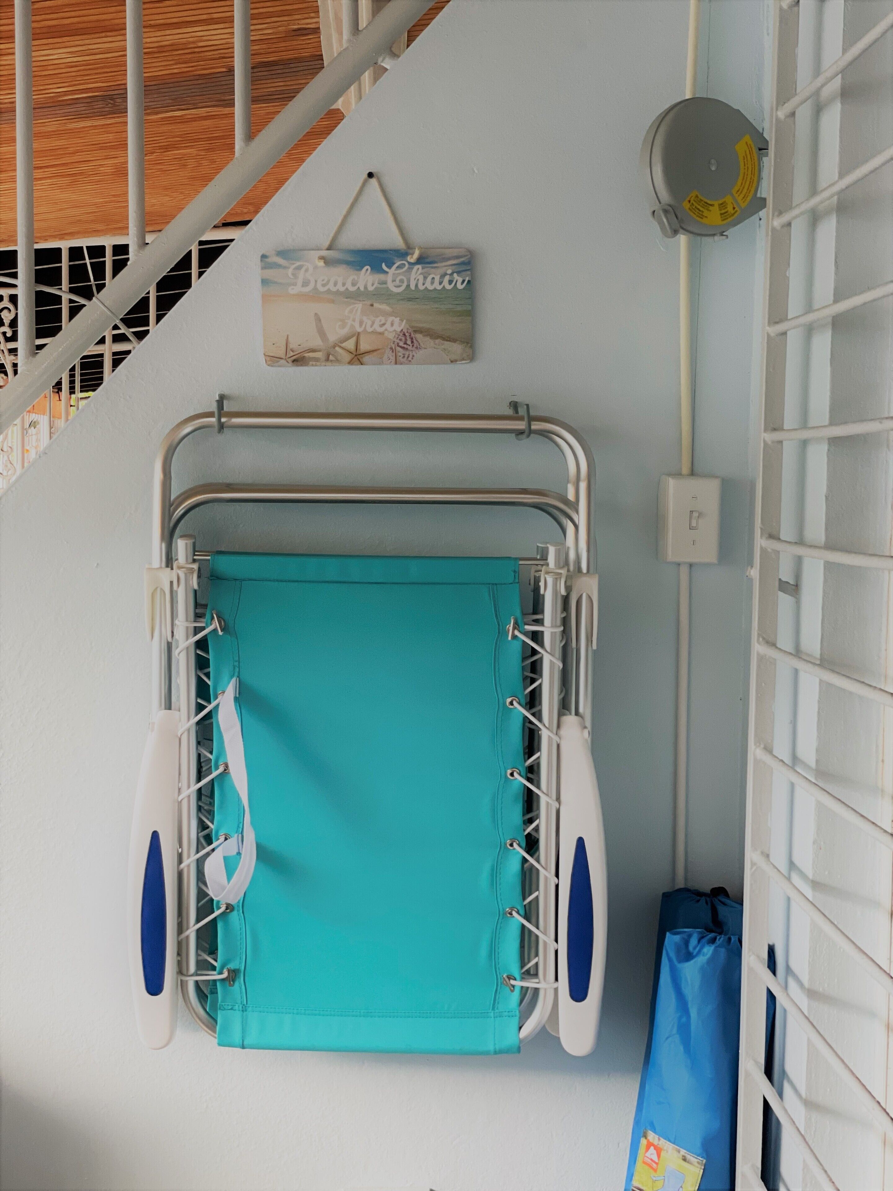A bathroom with a wheelchair-accessible shower chair, a towel rack, and a wall-mounted light fixture.