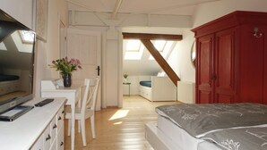 A bedroom with a bed, a desk, a chair, a red wardrobe, and a skylight. - Gorgeous apartment in Detern with WiFi (Detern)