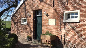 A brick building with a green door, two windows, and a sign that reads "Farnachung Klein Torsbach". - Gorgeous apartment in Detern with WiFi (Detern)