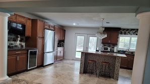 A spacious kitchen with wooden cabinets, a refrigerator, a microwave, and a sink. -  Luxury Estate with Dual Pools on 2.5 Acres Near Downtown Sarasota & Beaches (Sarasota)