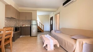 Een compacte woonruimte met een kitchenette, een eethoek en een slaapbank.