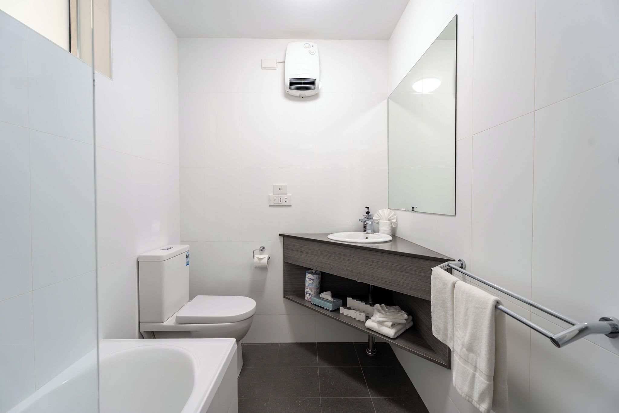 Une salle de bain moderne équipée de toilettes, d’un lavabo et d’une baignoire.
