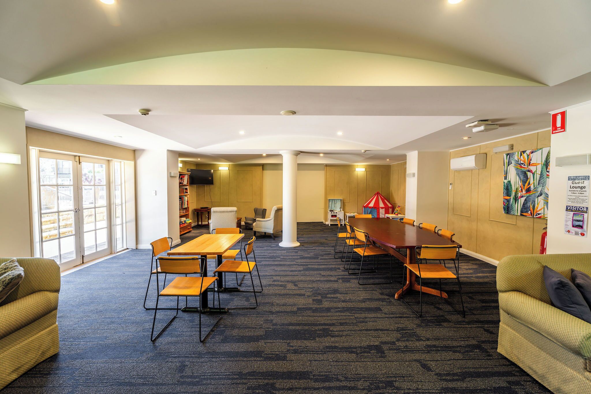 A conference room with a large table, chairs, and a sofa.
