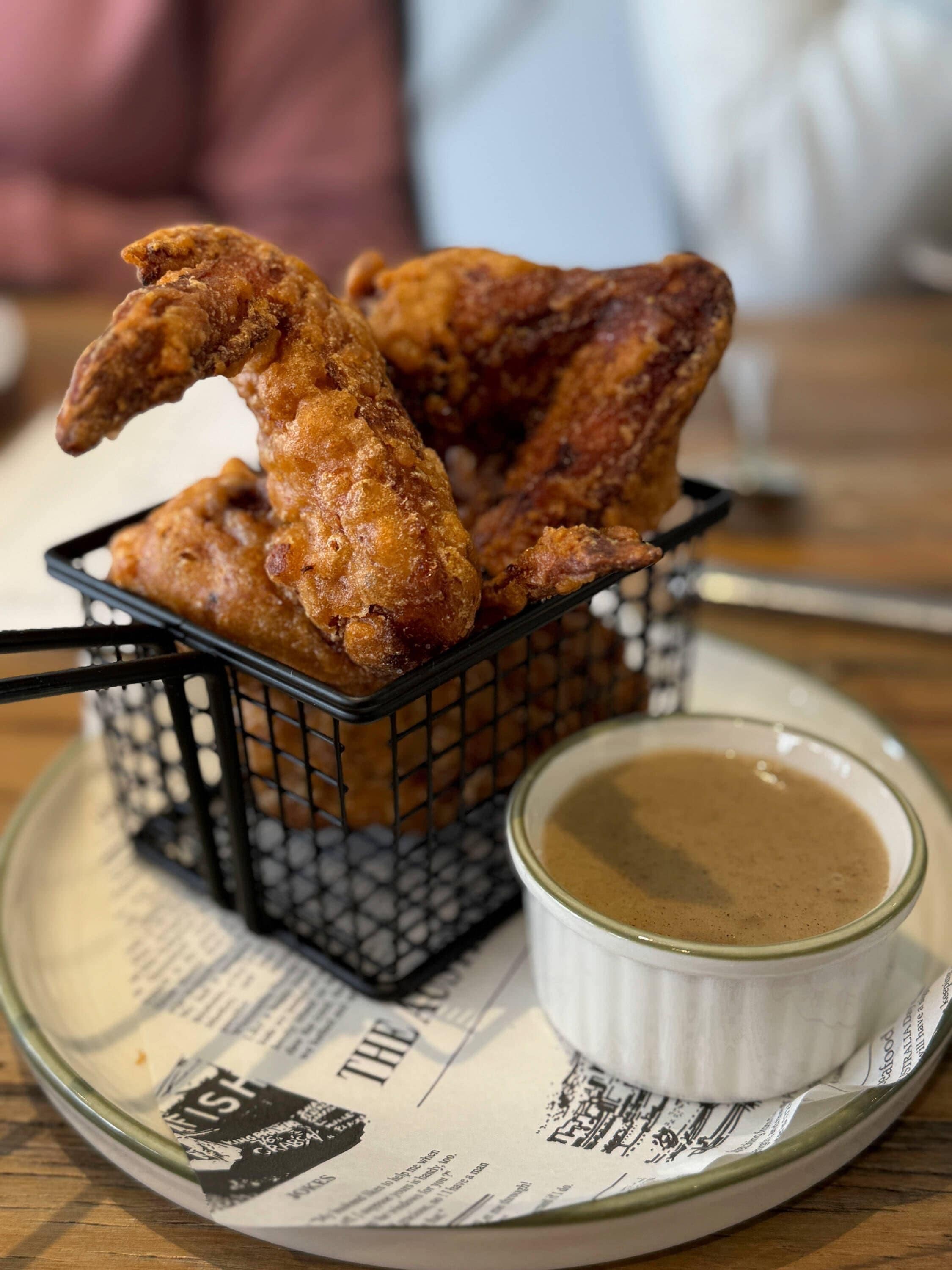 Eine Schüssel mit gebratenen Chicken Wings und einer Dipsoße.