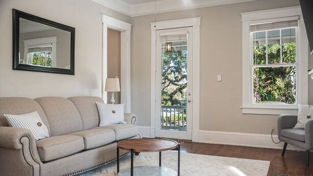Un salon avec un canapé beige, une table basse ronde et un tapis à motifs.