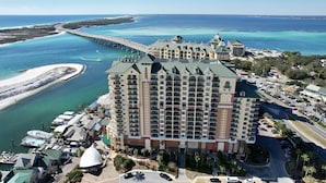 Un grand hôtel à étages, doté d’une cour intérieure et offrant une vue sur l’océan et un pont.