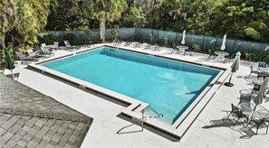 Una piscina rectangular con superficie de agua azul cristalina, rodeada por una solana con azulejos.